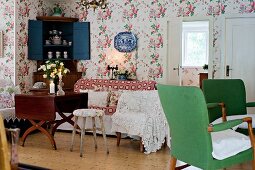 Armchairs with green upholstery, various seating and antique wooden table in rustic living room