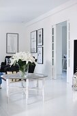 Vase of white lilies on tray table in black and white living room