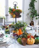 Herbstlich gedeckter Tisch mit Kürbisdeko, Etagere und Kerzen