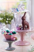 Easter sweets on china cake stands under glass covers