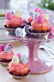 Easter cakes with topped with pink buttercream and sugar eggs on cake stand
