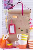 Roll of brown paper hung above shelf and decorated with paper clips, sticky notes, tags and pens