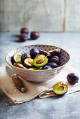 Fresh plums in a ceramic bowl