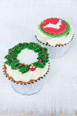 Lemon and chocolate cupcakes decorated with a wreath of holly and a reindeer