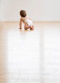 Baby crawling on hardwood floor