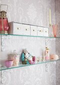 Row of vintage drawers, Chinese porcelain figurine and various knickknacks on glass shelves in shabby chic bathroom