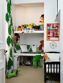 Eingebaute Regalböden mit Kissen und Spielsachen in Wandnische, seitlich bodenlanger Vorhang mit Blattmuster im Kinderzimmer