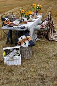 Table set with sunflowers and white linen tablecloth in stubbly field