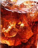 A glass of cola with ice and bubbles (close-up)