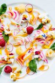 Vegetable salad with edible flowers, cream cheese and raspberries
