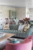 Sessel mit rosa weiss kariertem Bezug und graues Samtsofa mit Kissen um Couchtisch in romantischem, elegantem Landhauswohnraum