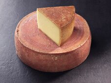 A wheel and a slice of Appenzeller cheese