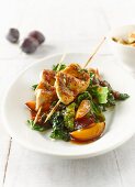 Chicken breast skewers with savoy cabbage, plums, bacon, shredded herb pancake and tomato sauce