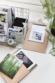 Postcards in wire basket next to blotter and tablet PC in case