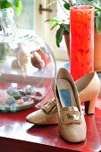 Goldenen Schuhe, rote Glasvase und Glasbehälter mit Edelsteinen