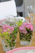 Posies in drinking glasses decorating table