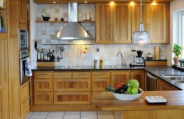 Contemporary fitted kitchen and wooden fronts and rod-shaped handles