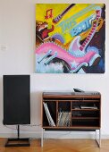 Modern painting above retro hifi cabinet with records in shelf compartment