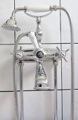 Vintage-style bath taps mounted on white-tiled wall