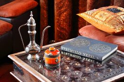 Orientalische Teekanne und Zuckerdose auf Beistelltisch mit Metaloberfläche