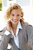 A young blonde woman wearing a white shirt and a Prince of Wales check blazer