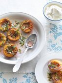 Caramelised nectarine halves with basil and pistachios served with whipped cream