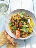 Chicken curry with chickpeas, beans and coriander on a bed of rice