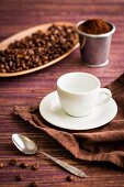 Kaffeebohnen, Kaffeepulver, Kaffeetasse und Kaffeelöffel