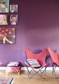 Butterfly chairs with dusky pink seats in front of purple-painted wall