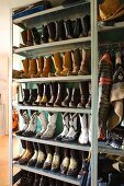 Metallregal mit Cowboystiefel-Sammlung, Lederjacke und Cowboyhut im Flurbereich