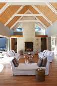 Offener Wohnraum mit Polstergarnitur und sichtbarer Dachstuhl mit Bambusabdeckung im Ärchitektenhaus