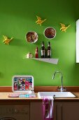 Minimalist kitchen counter with wooden worksurface, metal shelf and flying duck ornaments on wall