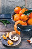 Clementines in a metal bowl on a rustic wooden table