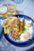 Lamm-Kebab mit Pitabrot, Salat und Harissasauce