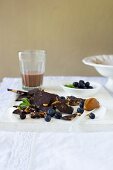 Dunkle Bruchschokolade mit Salted Caramel, frische Heidelbeeren und ein Glas Schokoladenmilch