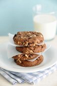 A stack of homemade hazelnut chocolate cookies with a glass of milk