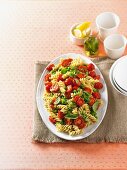 Warm pasta salad with roasted tomatoes, peas and pesto