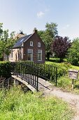 Traditionelles Wohnhaus mit Brücke in ländlicher Umgebung