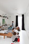 Geschwisterzimmer mit Holzbetten und Schreibtisch, am Fenster lange schwarze Vorhängen