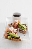 Wholemeal bread with tapenade, avocado, Parma ham and Parmesan cheese