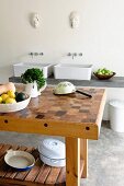 Küchentisch mit Hirnholz Platte, gegenüber Spültisch mit zwei Aufbaubecken, in minimalistischer Küche