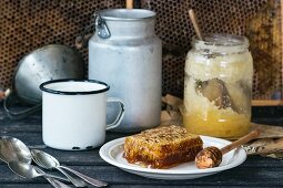 Honigwabe mit Honiglöffel und ein Glas alter Honig auf Holztisch
