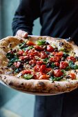 Marinara pizza with chicory being served