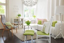 Romantisches Wohnzimmer, Stuhl mit grünem Sitzpolster und passendem Fussschemel, Sessel und gemütliches, weisses Sofa um Couchtisch