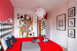 Farbintensives Schlafzimmer in rot mit Spielkarten-Motiv auf Wandschrank, schwarz-weißer Bildergalerie