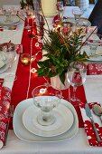 Gedeckter Tisch mit Weihnachtsdekoration und brennenden Windlichtern