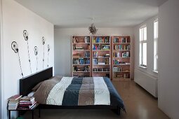 Sleeping area with designer wall lamps and bookcase