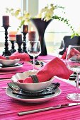 Place settings with hot pink linen napkins and place mats on festive table