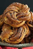 Chocolate and cinnamon buns with icing sugar on a pewter stand