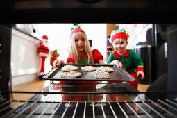 Two children baking Christmas biscuits